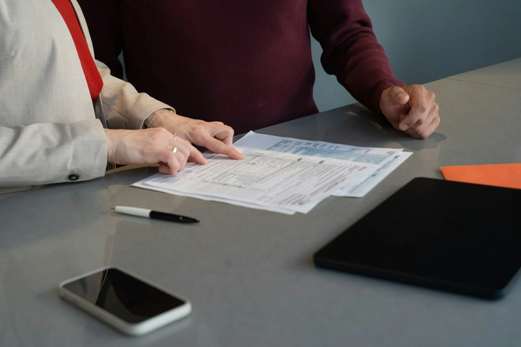 Two people going through paperwork together at a dining table