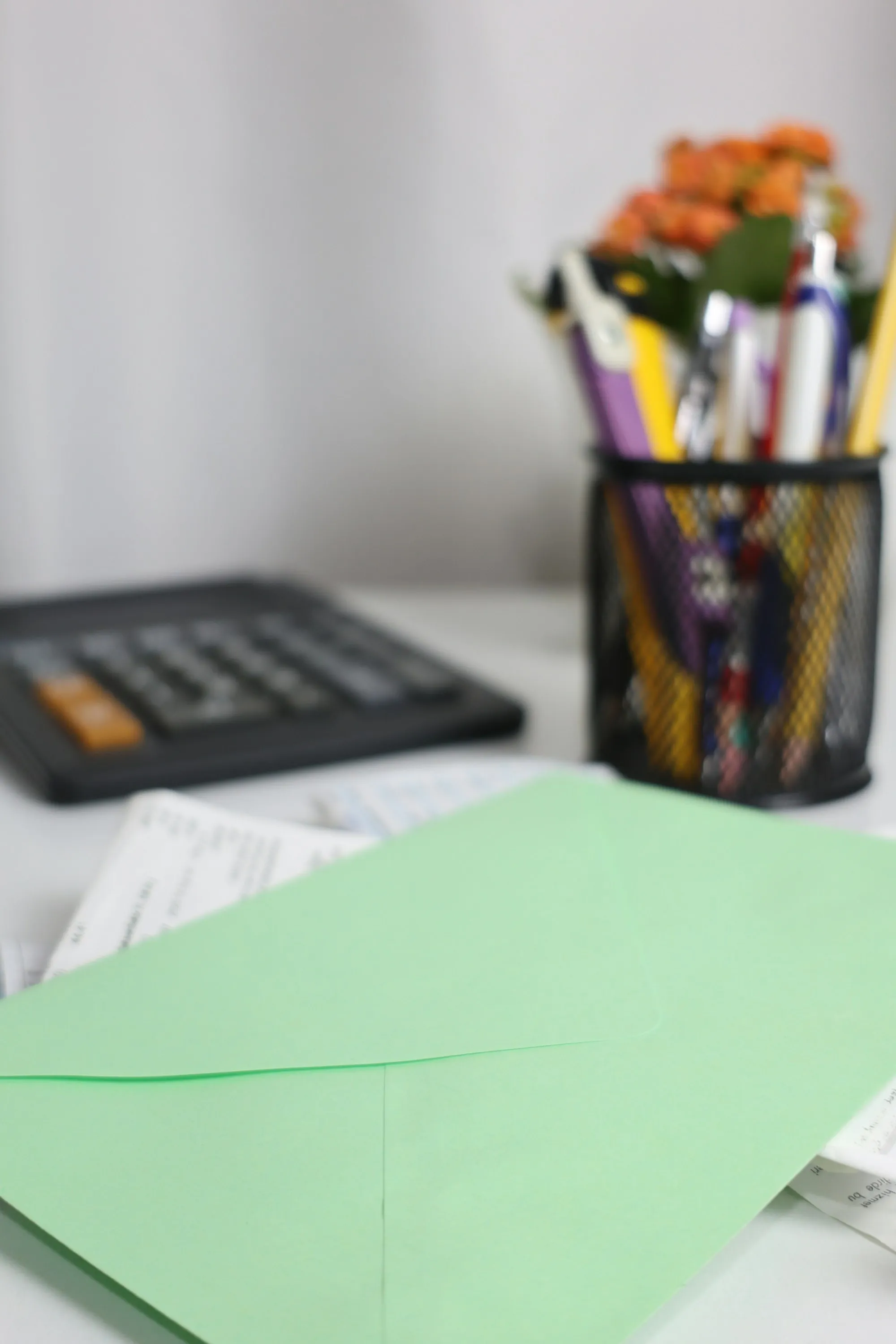 An envelope resting on a stack of papers beside a calculator